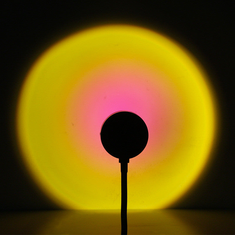 Melted Sun sunset projector, glowing yellow and pink light bulb on a black background
